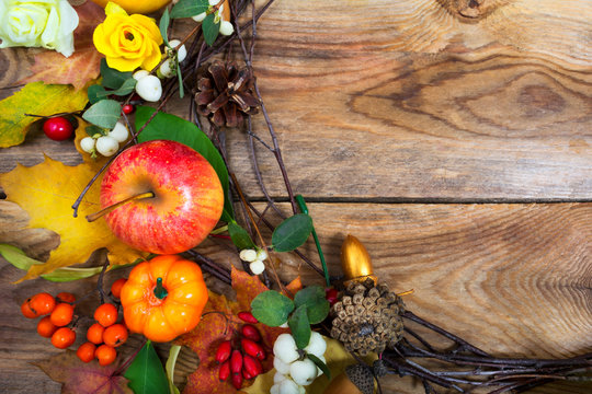 Holidays background with pumpkins, apple, maple leaves wreath, copy space