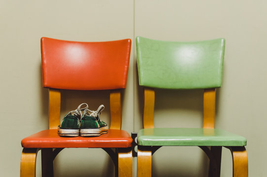 two retro chairs with a pair of green plaid sneakers
