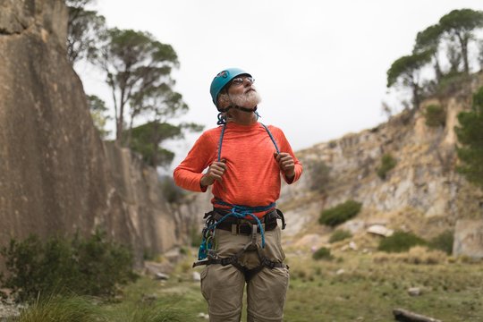 Senior man wearing safety equipment during mountaineering
