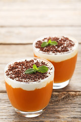 Pumpkin smoothie in glasses on wooden table