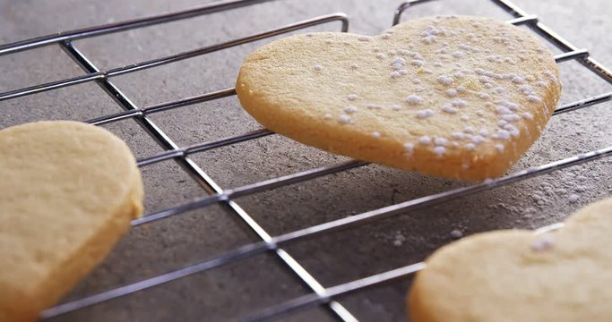 Raw heart shape cookies with sugar icing on baking tray 