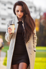 Portrait of self confidence business woman with coffee to go next to the office. Coffee to go