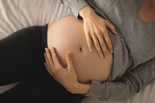 Pregnant woman sleeping on the bed