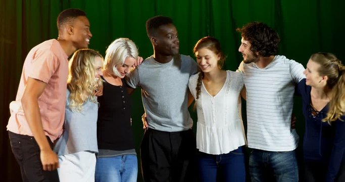 Actors team forming hands stack on stage 