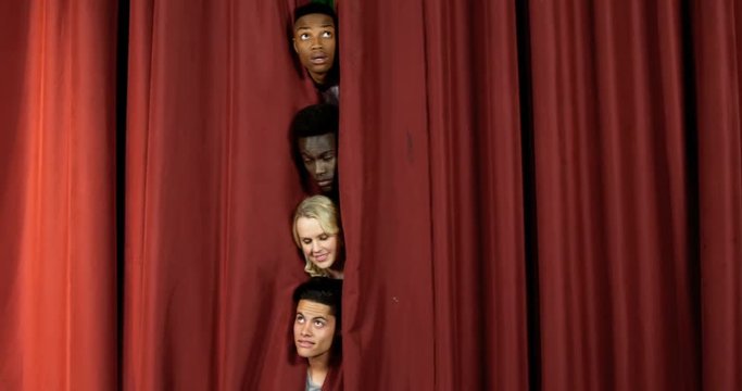 Actors peeping from curtain 