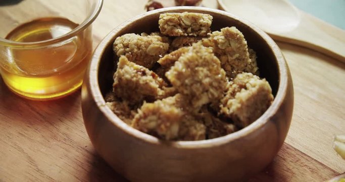 Granola bars in bowl with honey and fruits 
