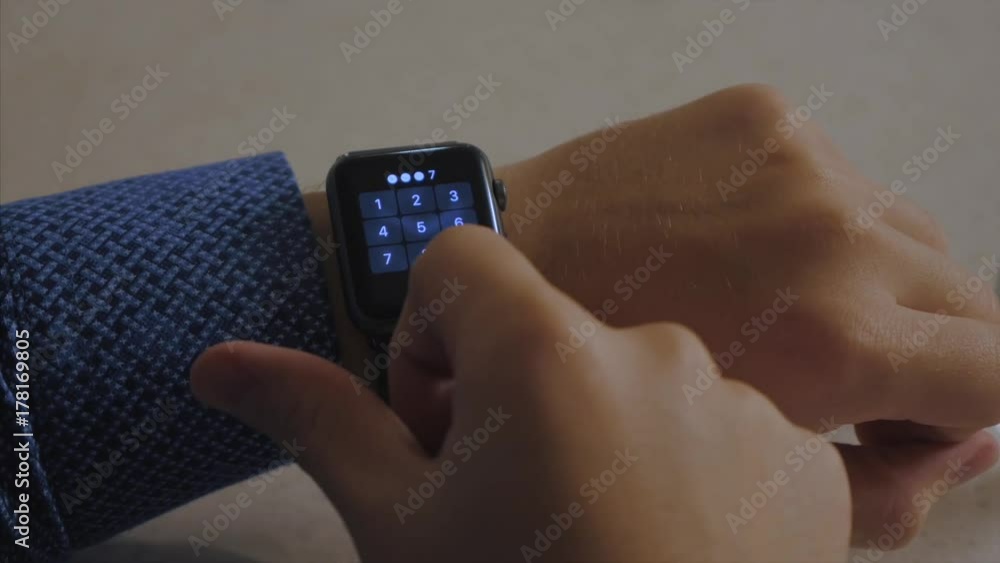 Poster man hand in watch with program on the screen against the background of table. man hand at the home w