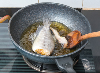 Fry fish Thai food style in hot oil in pan.
