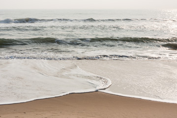 Foamy waves on calm beach - Foamy sea waves on a calm tropical beach in the morning.