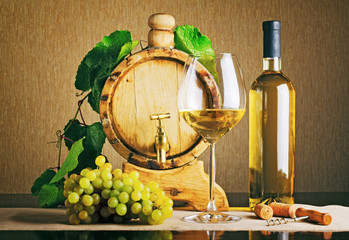 Wooden wine barrel with grape twig. Bottle of white wine