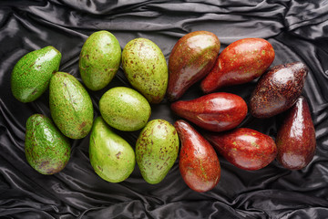 Colorful fresh ripe avocados on dark background. Healthy eco food