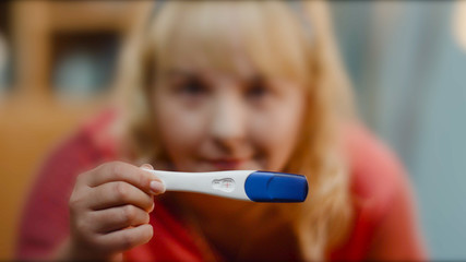 close up of woman holding pregnancy test. Young woman holding pregnancy test, shallow depth of field. Pregnancy Test showing a negative result