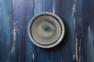 Fototapeta na wymiar Plate on blue wooden background