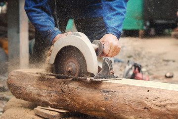 carpenter using saws  cutting woods at construction site