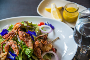 Dish of salad with fried crab and orange sauce