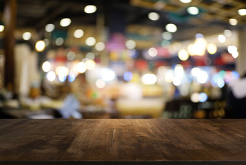 Empty dark wooden table in front of abstract blurred background of cafe and coffee shop interior. can be used for display or montage your products