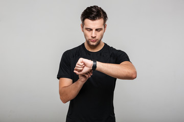 Portrait of a focused young sportsman adjusting his wristwatch