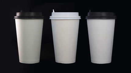 Three disposable coffee cups on black background