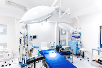 Modern hospital interior. Details of medical equipment with lamps and operating table