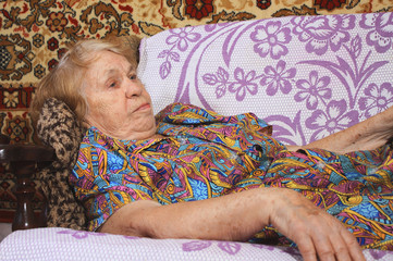 elderly woman lying in bed and carpet background
