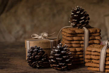 Obraz na płótnie Canvas Christmas atmosphere with biscuits and pine cone on rustic background