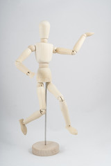 a wooden dummy posing while running	