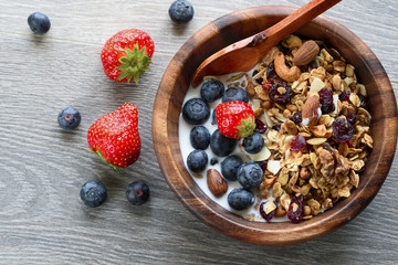Homemade  granola with  fresh berry in wooden bowl