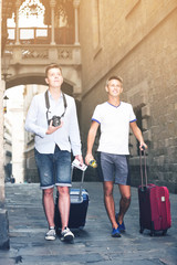 Fototapeta na wymiar Guys travellers couple in casual clothes with trunk