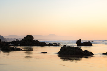 Beach with rocks in Biarritz city at sunset, Basque country of France