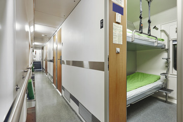Obraz premium Train berth vorridor indoor with two beds. Travel background.