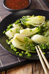 Stir Fry spicy baby bok choy close-up and a sweet chili sauce. vertical