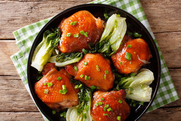 Spicy roasted chicken thighs with bok choy and green onions close-up. Horizontal top view