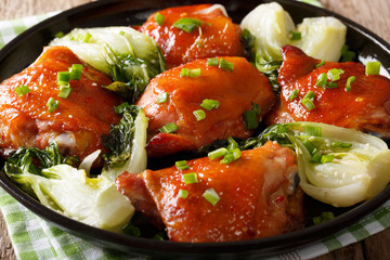 Delicious fried chicken thighs with bok choy and green onions close-up. horizontal