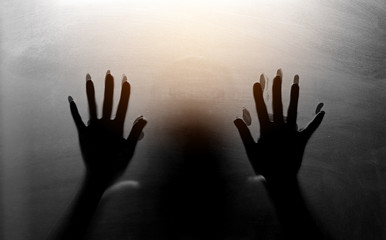 Shadowy figure behind glass. Fear and panic concept.