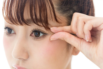 Naklejka premium 目尻をつまむ女性