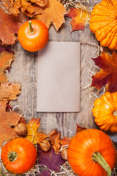 Thanksgiving background with orange pumpkins and colourful leaves on wooden board with copyspace. Autumn idea.