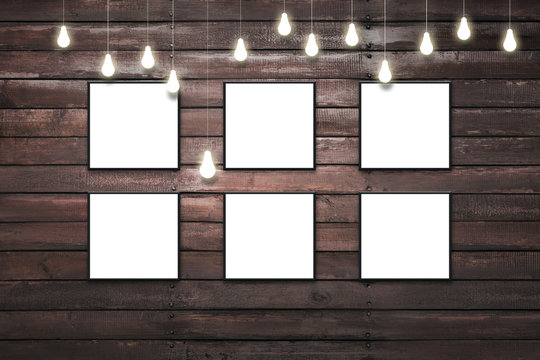 Rustic wooden plank wall with isolated white posters in black frames