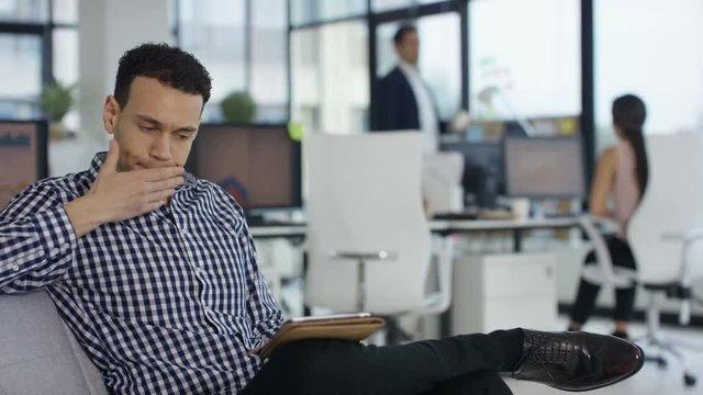  Business team working in modern office, focus on man lying down for a rest