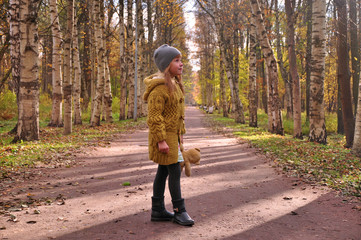 The little girl walks in autumn Park