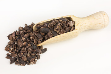 crushed organic cocoa nibs on a wooden scoop