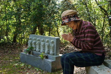 Elderly woman visiting the family grave