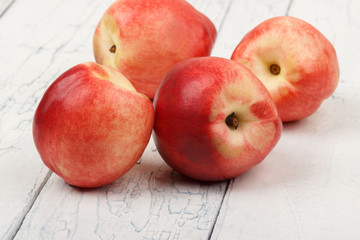 Ripe red peaches on the white wooden table