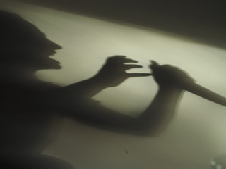 Gruseliger Schatten einer angreifenden Person mit Messer