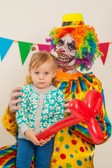 a terrible clown and a child. Halloween. The crazy clown. Childish fear