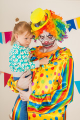 a terrible clown and a child. Halloween. The crazy clown. Childish fear