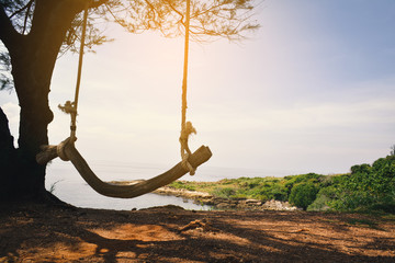 Obraz premium wooden swing on beautiful sea with sunlight ,concept time to travel in vacation