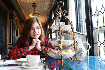 Young and beautiful girl expect the sweet with england style tea time background