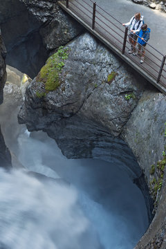 Tourist admiring Trummelbach ice waterfall formed by melting waters of glaciers Eiger, Monch and Jungfrau,Lauterbrunnen Valley, Canton Bern, Switzerland