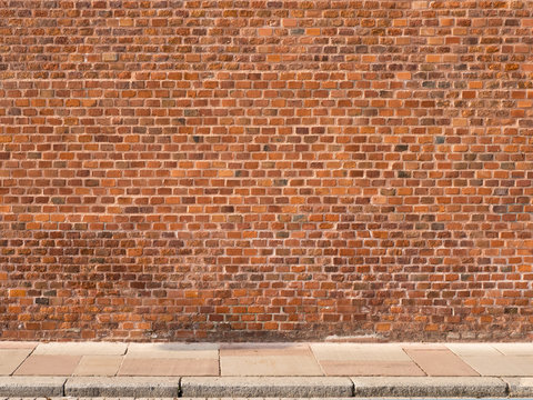 Fototapeta Red brick wall with sidewalk