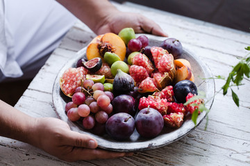 Person serving tray full of fresh seasonal fruits
